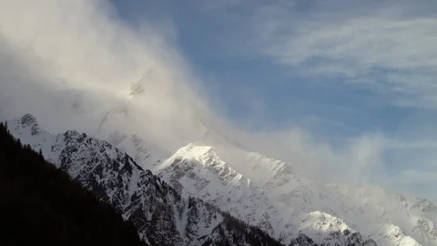 Time-lapse of clouds moving over the snowy mountain Stock Footage 116789372