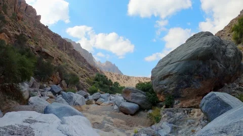 Time Lapse of Clouds moving over mountains with a small dried up river Stock Footage 147430934