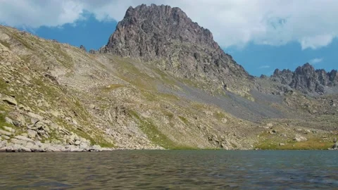 Time-lapse of clouds moving over mountain peaks and clear mountain lake on a Stock Footage 160101593