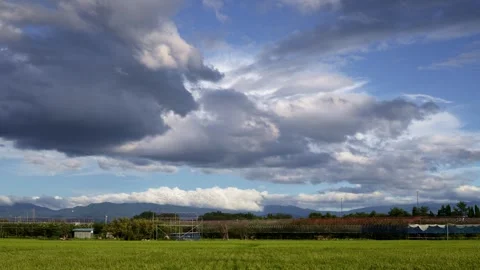 Time lapse of clouds moving over a rice paddy Stock Footage 247562893