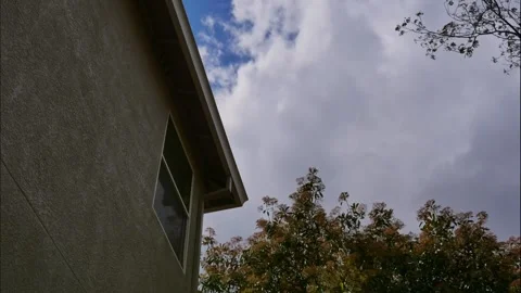 Time lapse with clouds moving over a two story stucco house Stock Footage 307639086