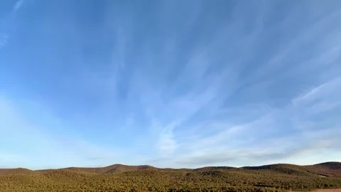 Time lapse clouds moving over wooded hills in blue sky. Stock Footage 328336763