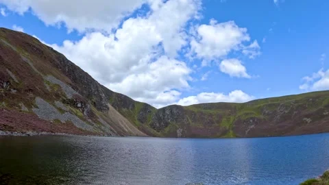 Time lapse clouds moving over stunning mountain lake and heather landscape .. Vídeo Stock 334318276