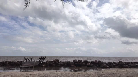 Time lapse of clouds moving over rocky beach shoreline and wooden bridge Stock Footage 340253977