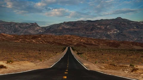Time lapse of clouds moving over empty desert highway in Death Valley National Stock Footage 344450489