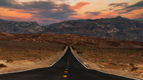 Time lapse of clouds moving over empty desert highway in Death Valley National Stock Footage 344450561