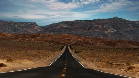 Time lapse of clouds moving over empty desert highway in Death Valley National Stock Footage 345177523