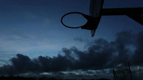 Time lapse of clouds moving past a basketball ring as day turns to night Stock Footage 34278504