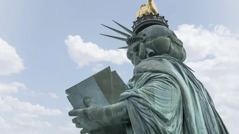 Time lapse of clouds moving past the Statue of Liberty in New York City, USA Video stock 129773007