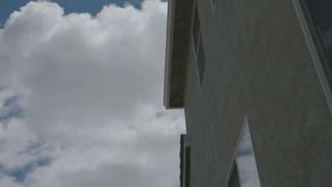 Time lapse of clouds moving past a residential house Vídeos de archivo 338035091