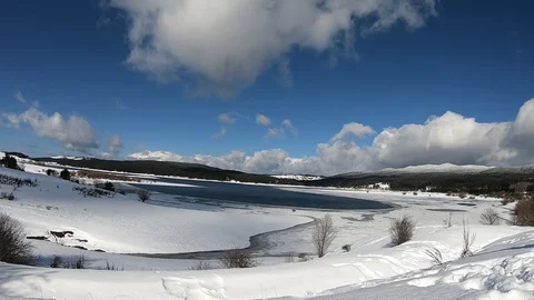 Time lapse of clouds moving on a snowy landscape with a lake Stock Footage 119501699