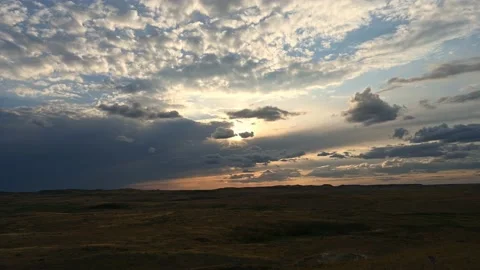 Time lapse of clouds moving in two directions at sunset over a badlands desert s Vídeo Stock 209721473