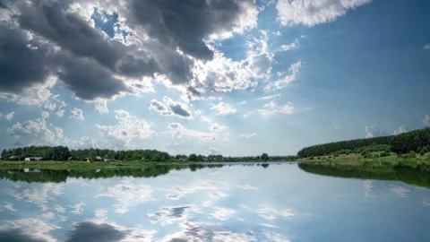 Time lapse of clouds over a beautiful forest lake, reflection of clouds in water Stock Footage 265509804