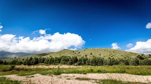 Time lapse clouds over green, yellow meadow Stock Footage 41815488