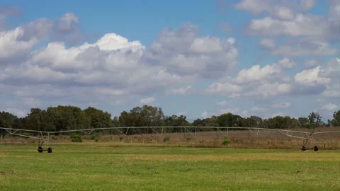 Time lapse Clouds over green grass and a centre pivot sprayer Stock Footage 164845541