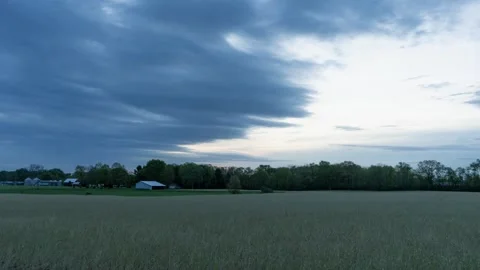 Time lapse of clouds over a hay field in the early morning Stock Footage 334683392