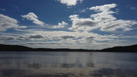 Time lapse of clouds over the lake, forest on background. Finland nature Video stock 111879978