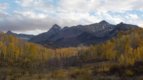 Time lapse of clouds over the Rocky mountains and a valley of yellow trees Stock Footage 75797513