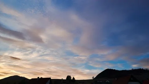 Time-lapse clouds over the roofs of houses in the village .,pastel colored Video stock 236415669