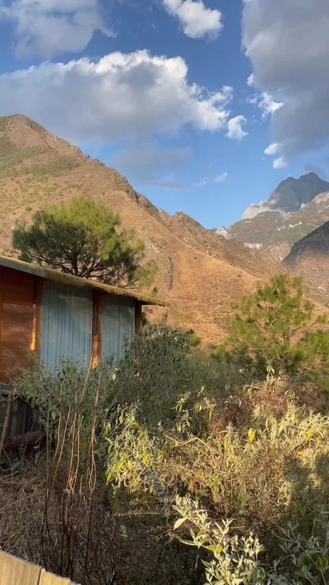 Time-lapse of Clouds Over Rustic Cabin and Jade Dragon Snow Mountain Video stock 330097363