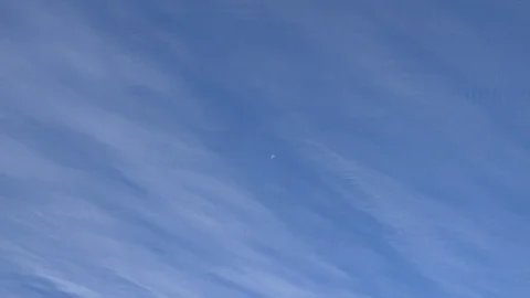 Time lapse clouds passing in front of the moon during the day Stock Footage 93936798