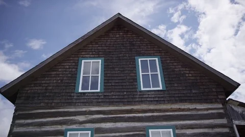 Time lapse clouds passing by old log cabin home Stock Footage 79506881