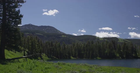 Time lapse of clouds passing over mountain lake in Yellowstone on summer day Stock Footage 64135890