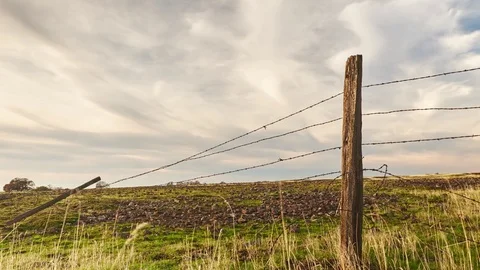 Time Lapse of Clouds Passing over a Broken Barbwire Fence. Stock Footage 70150861