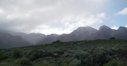 Time lapse of clouds passing over mountains from green valley Stock Footage 277389945