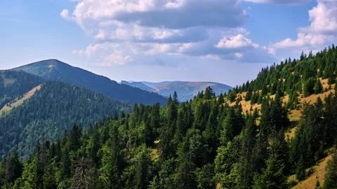 Time-lapse of clouds passing over a forest, mountains 스톡 동영상 285624429