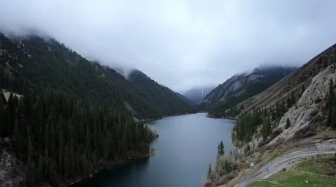 Time Lapse clouds rise from trees in the mountain lake Video stock 63552736