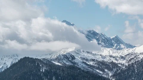 Time lapse of clouds rolling and flowing over winter  peaks Stock-Footage 83705595