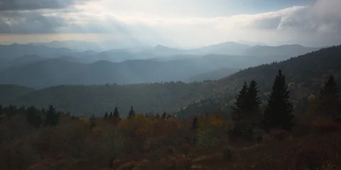 Time-lapse of clouds rolling over the autumn forest and mountains at sunset Stock Footage 103398831