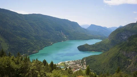 Time-lapse of clouds rolling over the green mountain ranges and beautiful lake Stock Footage 109294815