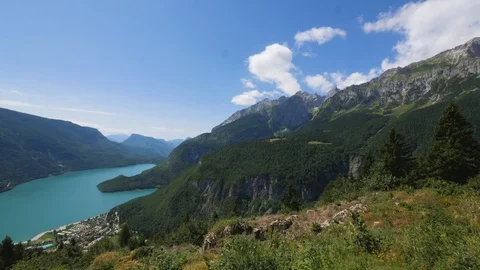 Time-lapse of clouds rolling over the green mountain ranges and beautiful lake Stock Footage 109295064