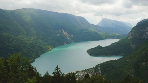 Time-lapse of clouds rolling over the green mountain ranges and beautiful lake Stock Footage 109295148