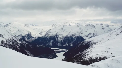 Time-lapse of clouds rolling over snow covered mountain ranges Stock Footage 113249766