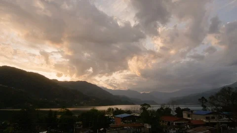 Time-lapse of clouds rolling over mountains and a lakeside village Stock Footage 113255834