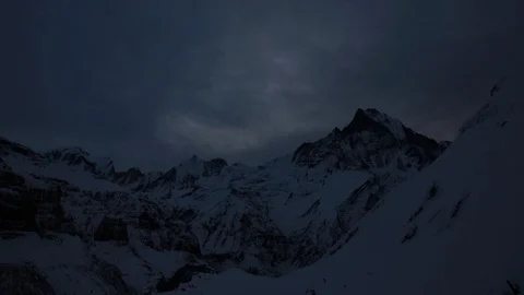 Time-lapse of clouds rolling over snowy mountains, night to day Stock Footage 113255977