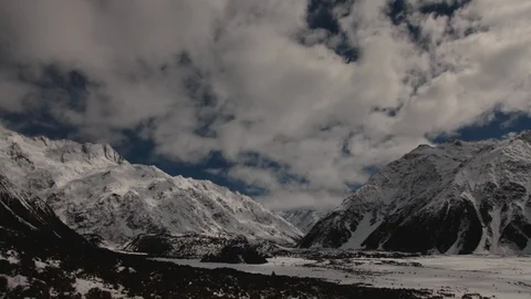Time-lapse of clouds rolling over the snow covered mountains Stock Footage 116749805
