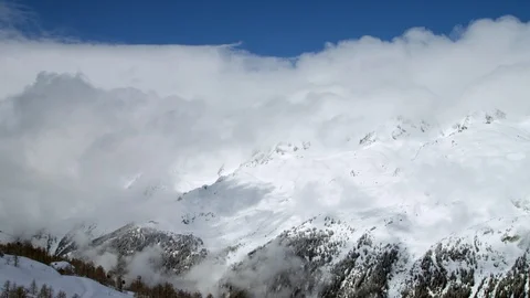 Time-lapse of clouds rolling over the snow covered mountain Stock Footage 116789274