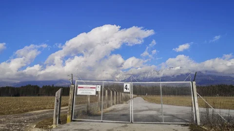 Time lapse clouds rolling over Alps. In foreground Ljubljana airport fence Stock Footage 128358589