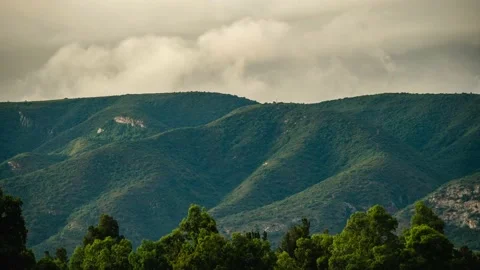 Time-lapse of clouds rolling over mountain top sunset Stock Footage 233790569