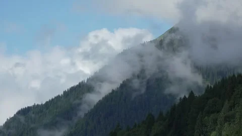 Time Lapse of Clouds Rolling Over Forested Mountain Hills in the Alps Stock Footage 317078294