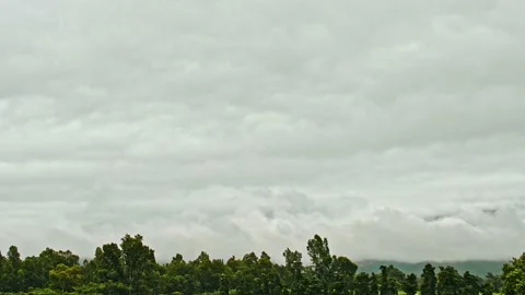 Time-lapse of clouds rolling past a mountain range on farm Stock Footage 233735171