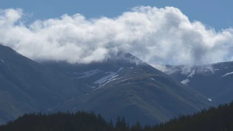 Time Lapse of the Clouds in the snowy mountains in summer. 4k Stock Footage 123543856