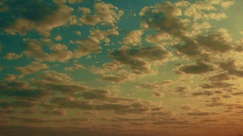 Time-lapse of clouds at sunrise or sunset - green and orange warm lights Stock Footage 254968435