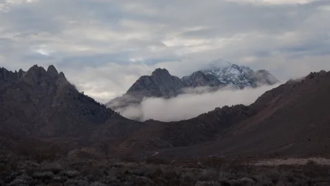 Time lapse of clouds swirling around a snowy mountain peak in the Sierra Nevada Stock Footage 144707164