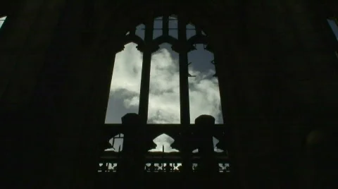 Time-lapse clouds through broken arched church window Stock Footage