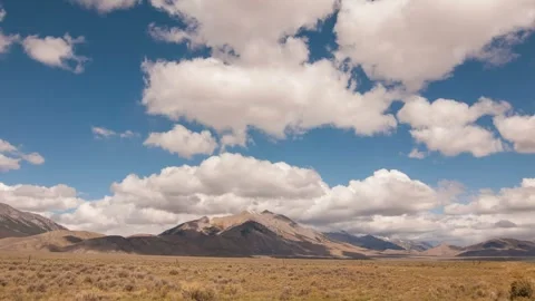 Time lapse clouds travel over plains and mountains Stock Footage 246172209